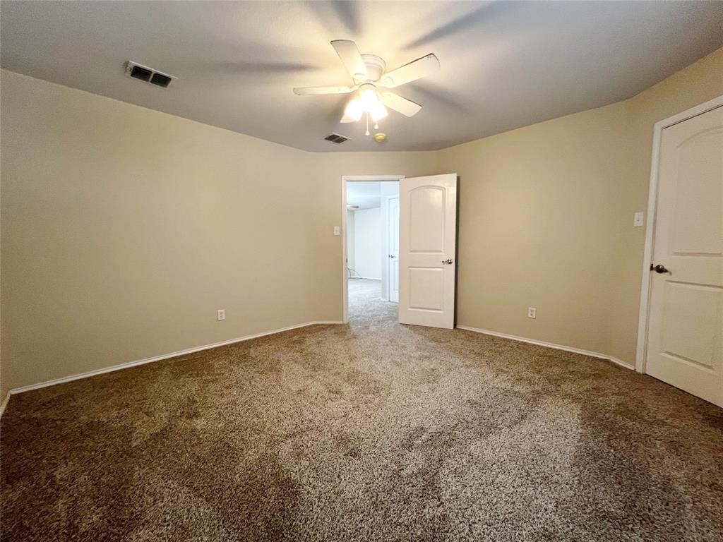 8813 Chisholm Trail Cross Roads, TX 76227 - Photo 22 of 24 an empty room with a ceiling fan and carpet