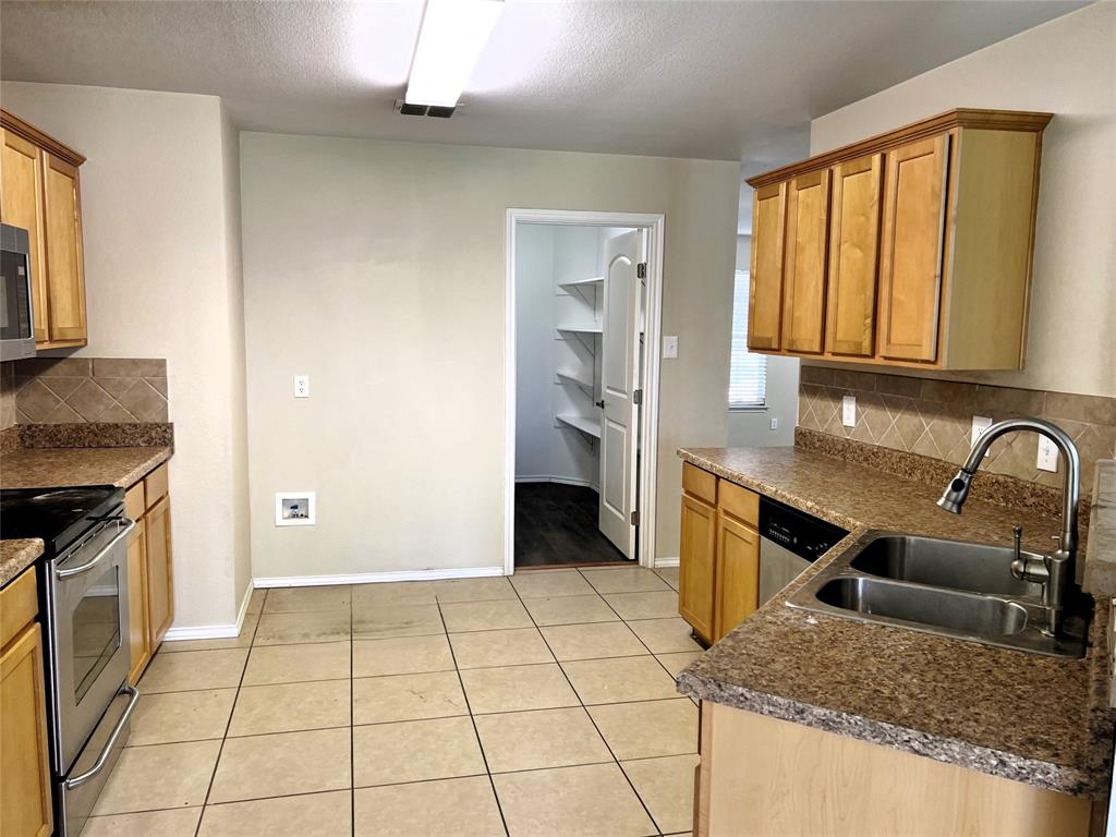 8813 Chisholm Trail Cross Roads, TX 76227 - Photo 8 of 24 a view of a kitchen with kitchen island granite countertop a stove top oven a sink a counter space and cabinets