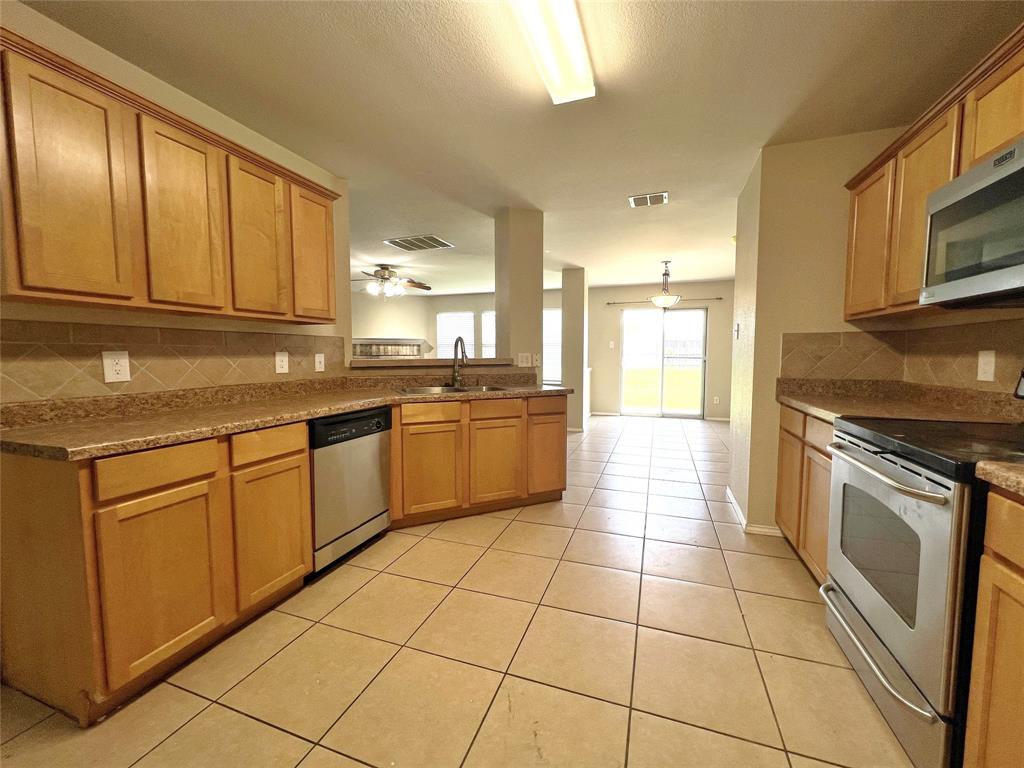 8813 Chisholm Trail Cross Roads, TX 76227 - Photo 9 of 24 a kitchen with a sink a stove top oven and cabinets