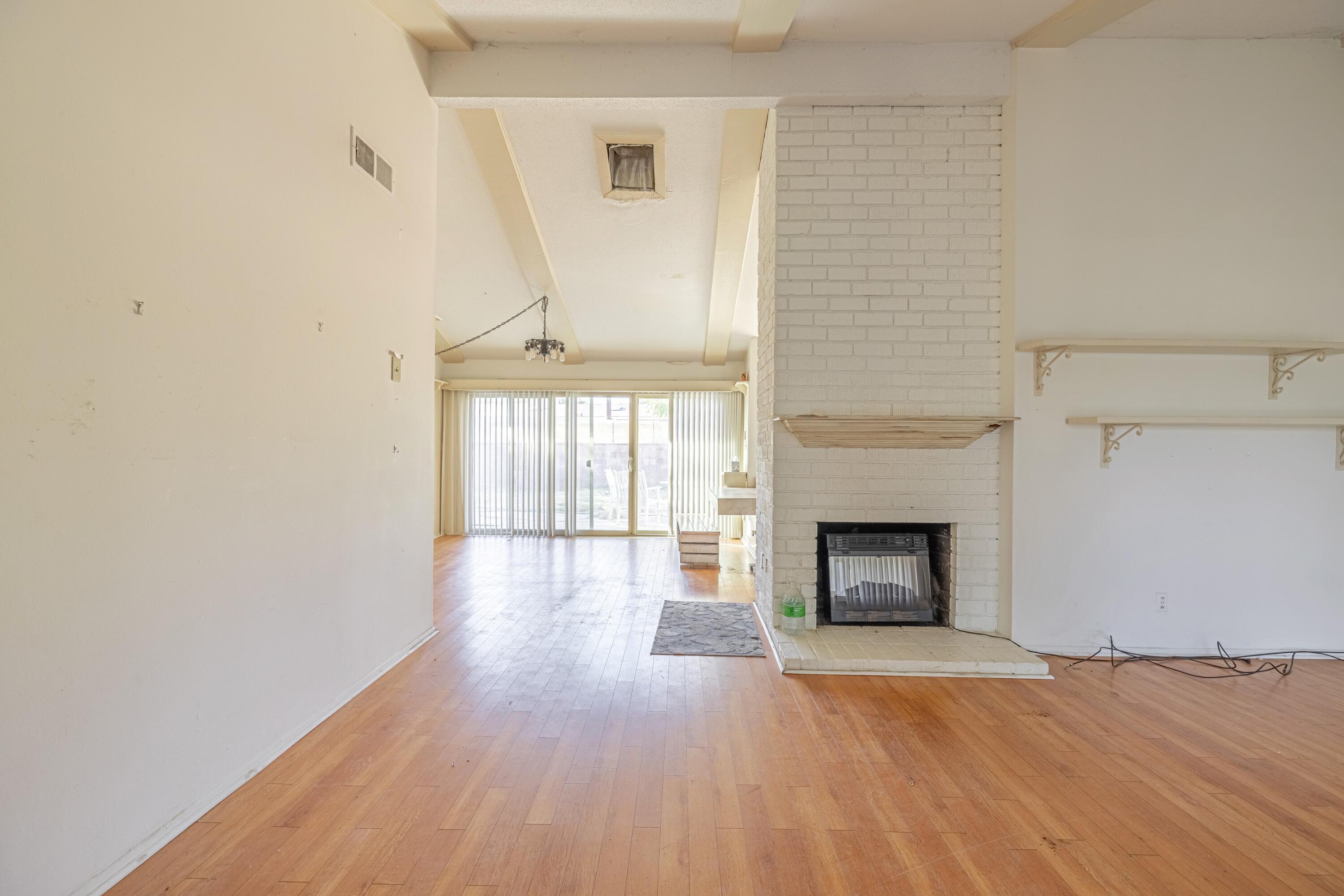 1108 Valiant Street Lancaster, CA 93534 - Photo 4 of 21 an empty room with wooden floor fireplace and windows