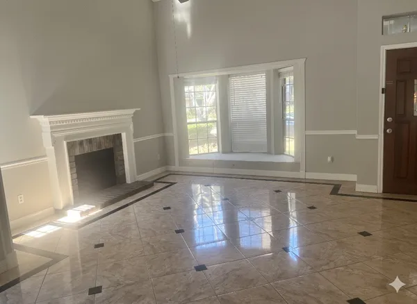 a view of an empty room with a fireplace and a window