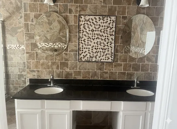 a bathroom with a sink a granite counter and a mirror