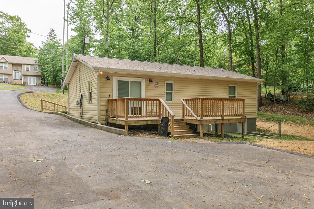 482 Round Up Road Lusby, MD 20657 - Photo 18 of 19 a view of a house with a yard and deck area