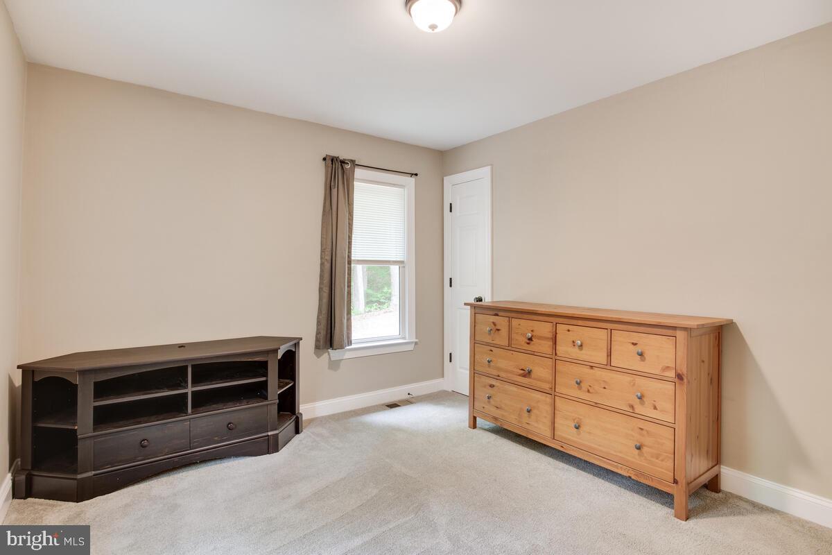 482 Round Up Road Lusby, MD 20657 - Photo 10 of 19 a room with furniture a dresser and a window