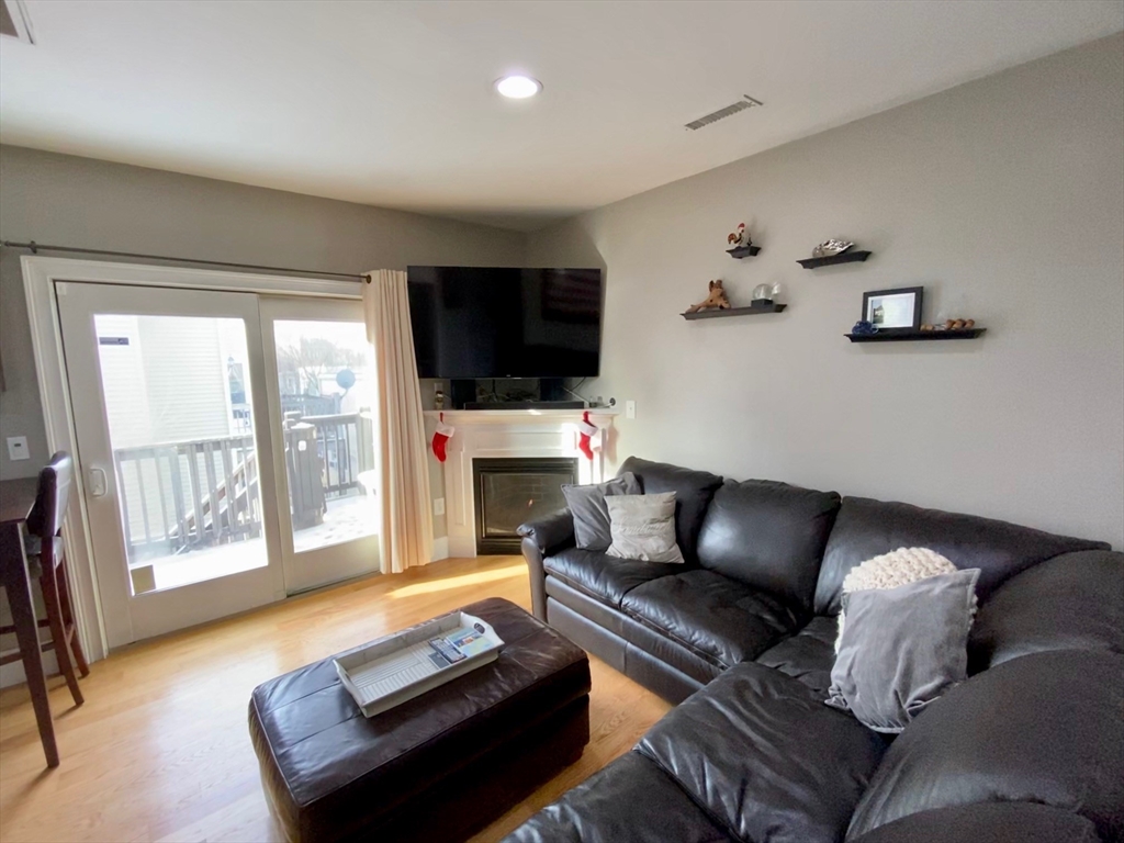 227 Bowen Street, Unit 3 Boston, MA 02127 - Photo 1 of 9 a living room with furniture a flat screen tv and a fireplace