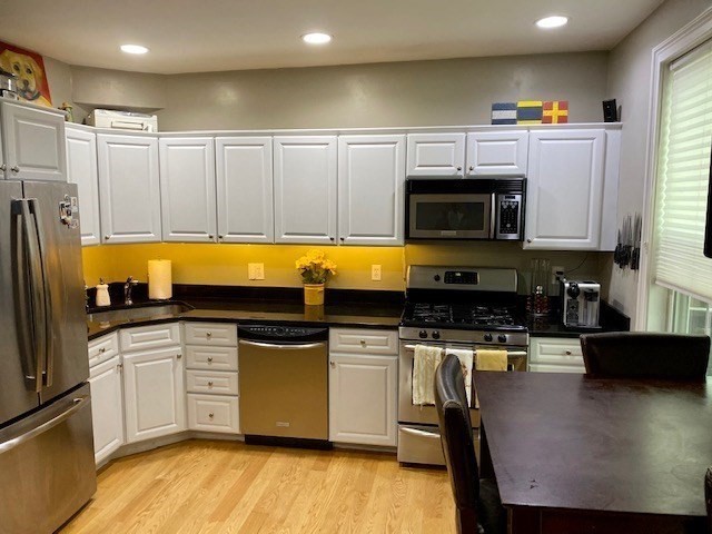 227 Bowen Street, Unit 3 Boston, MA 02127 - Photo 2 of 9 a kitchen with stainless steel appliances a stove a sink a microwave a refrigerator a stove and white cabinets