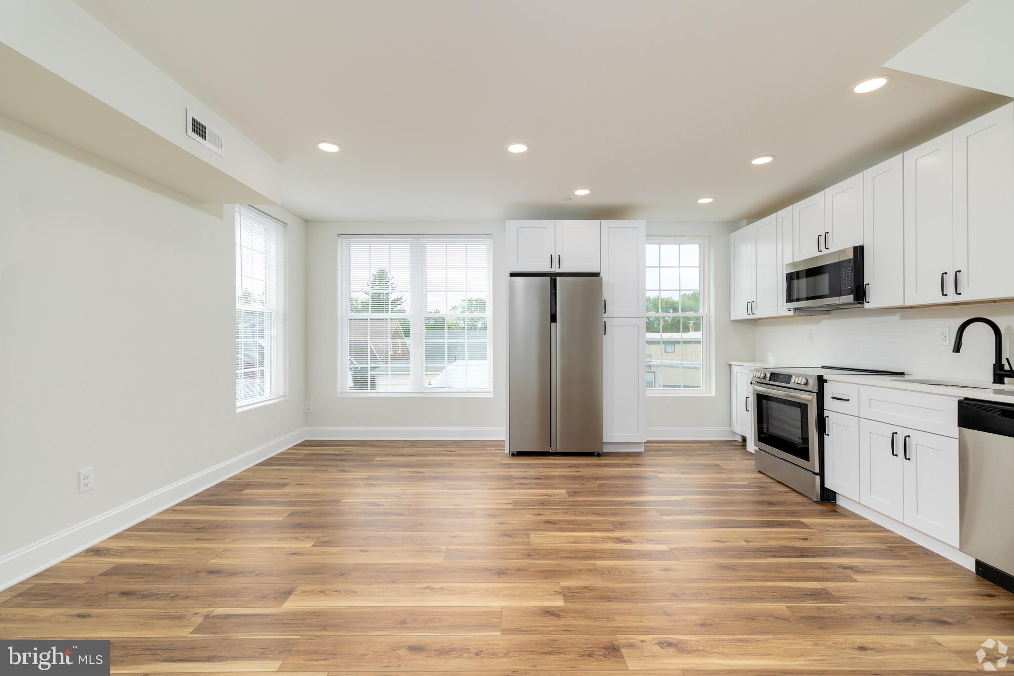 a view of kitchen with granite countertop cabinets and refrigerator