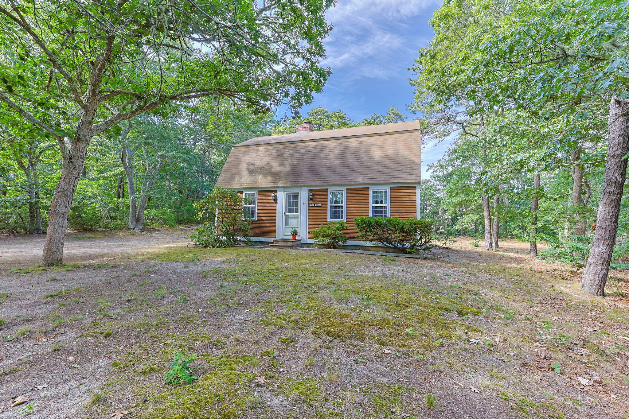 a front view of a house with a yard and trees