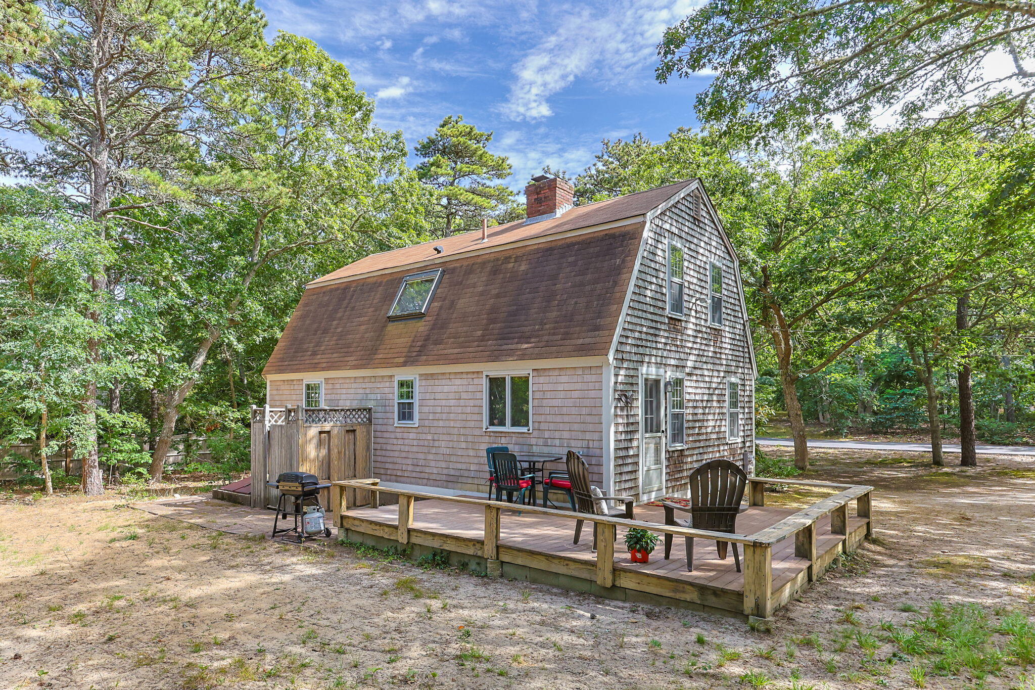 65 Cestaro Way Eastham, MA 02642 - Photo 33 of 40 a view of backyard with table and chairs and a large tree