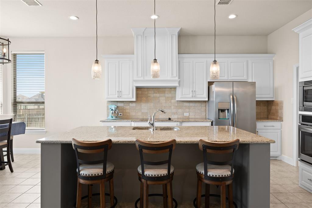 2618 Byrd Ranch Road Midlothian, TX 76065 - Photo 20 of 38 a kitchen with a dining table chairs and white cabinets