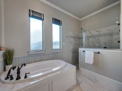 a bathroom with a granite countertop sink a large mirror and a bathtub