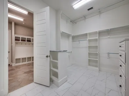 a kitchen with white cabinets and a window