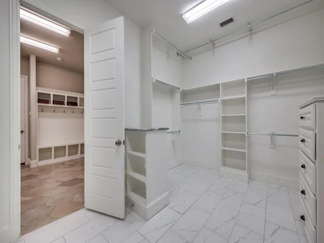 a kitchen with white cabinets and a window