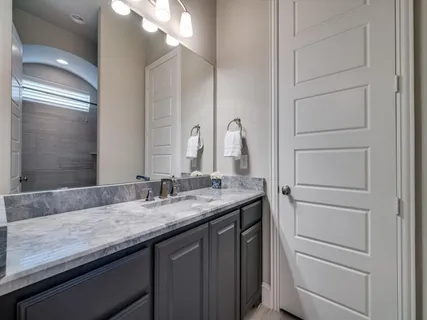 an empty room with chandelier fan and windows