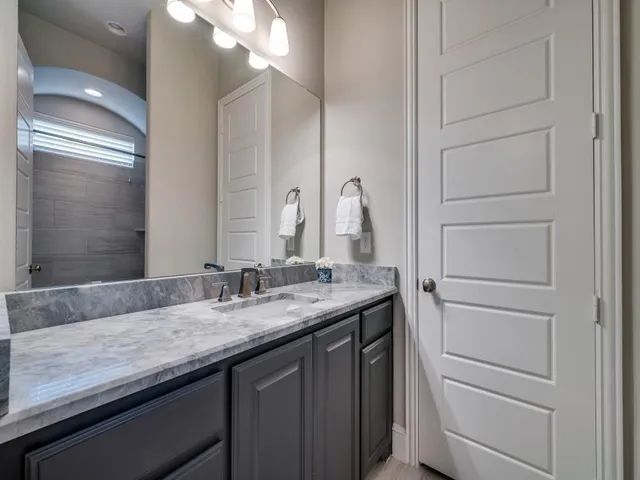 an empty room with chandelier fan and windows