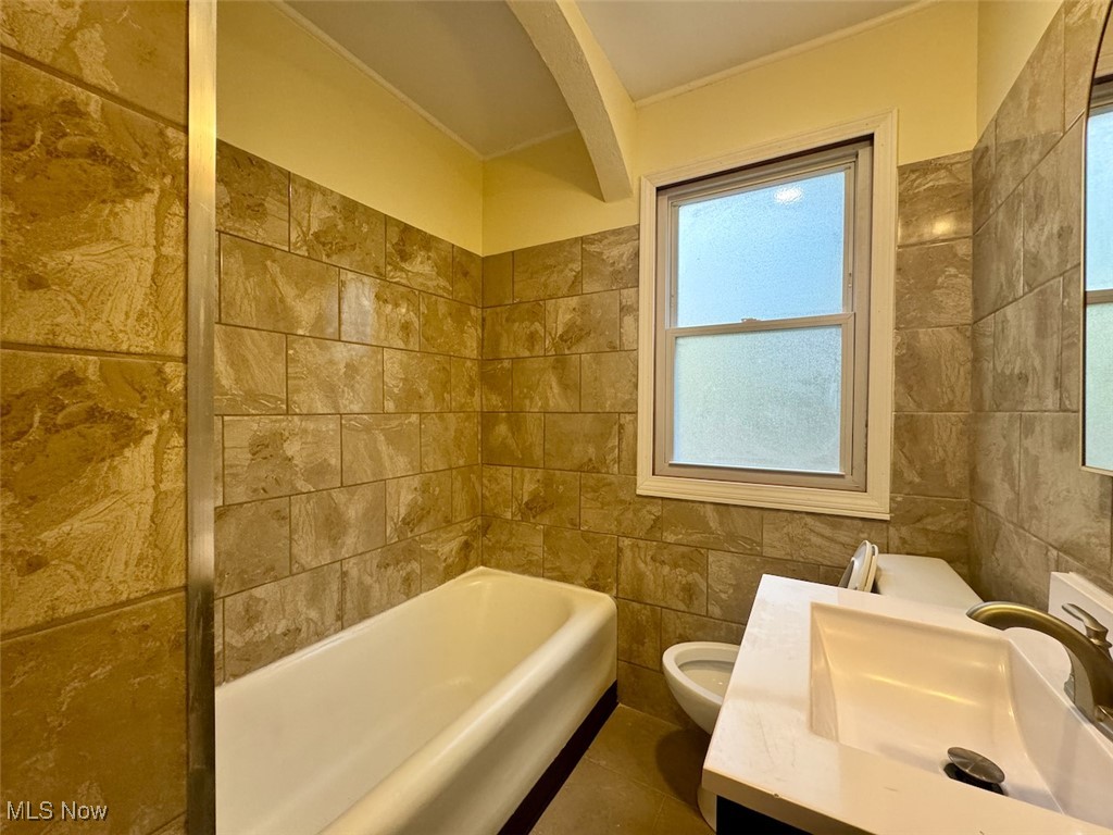 4595 Tiedeman Road Cleveland, OH 44144 - Photo 18 of 29 Bathroom with a bathtub, vanity, tile patterned flooring, toilet, and tile walls