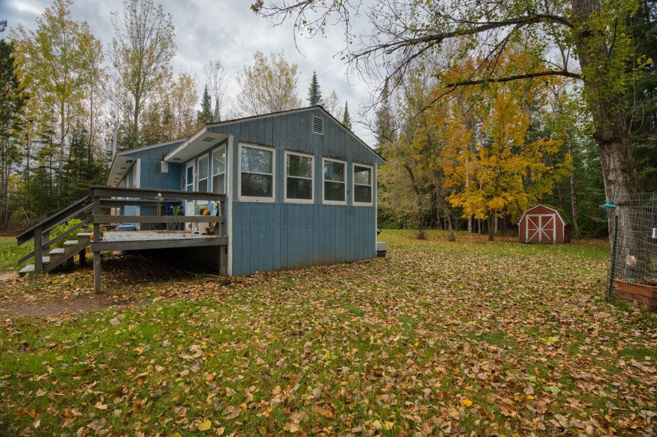 5462 Twin Lakes Loop 45 Aurora, MN 55705 - Photo 24 of 42 Back of property featuring a deck, a sunroom, stairway, a shed, and a lawn