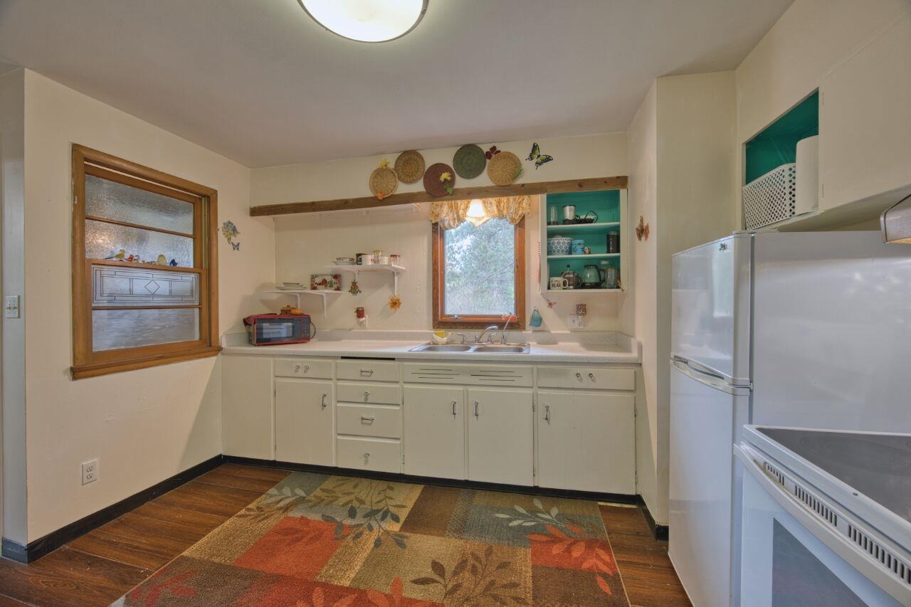 5462 Twin Lakes Loop 45 Aurora, MN 55705 - Photo 8 of 42 Kitchen featuring open shelves, light countertops, dark wood-style flooring, white cabinetry, and white electric range