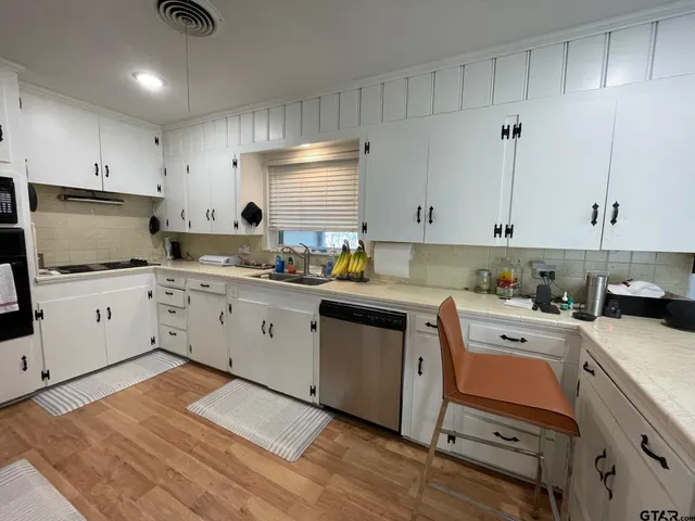 a kitchen with a sink white cabinets and white appliances