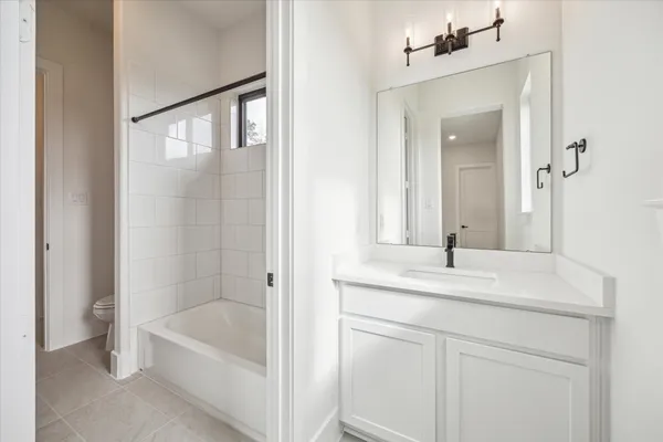a bathroom with a tub sink and mirror
