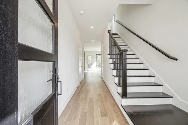 a view of a hallway with wooden floor and staircase