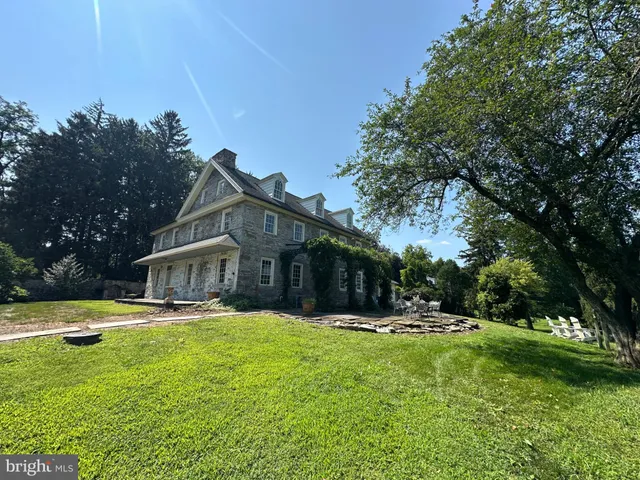 a view of a house with a big yard and palm trees