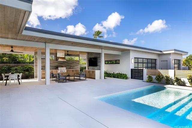 a view of a patio with table and chairs and a barbeque