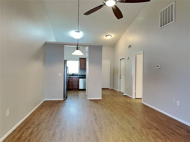 a view of a room with a ceiling fan and wooden floor