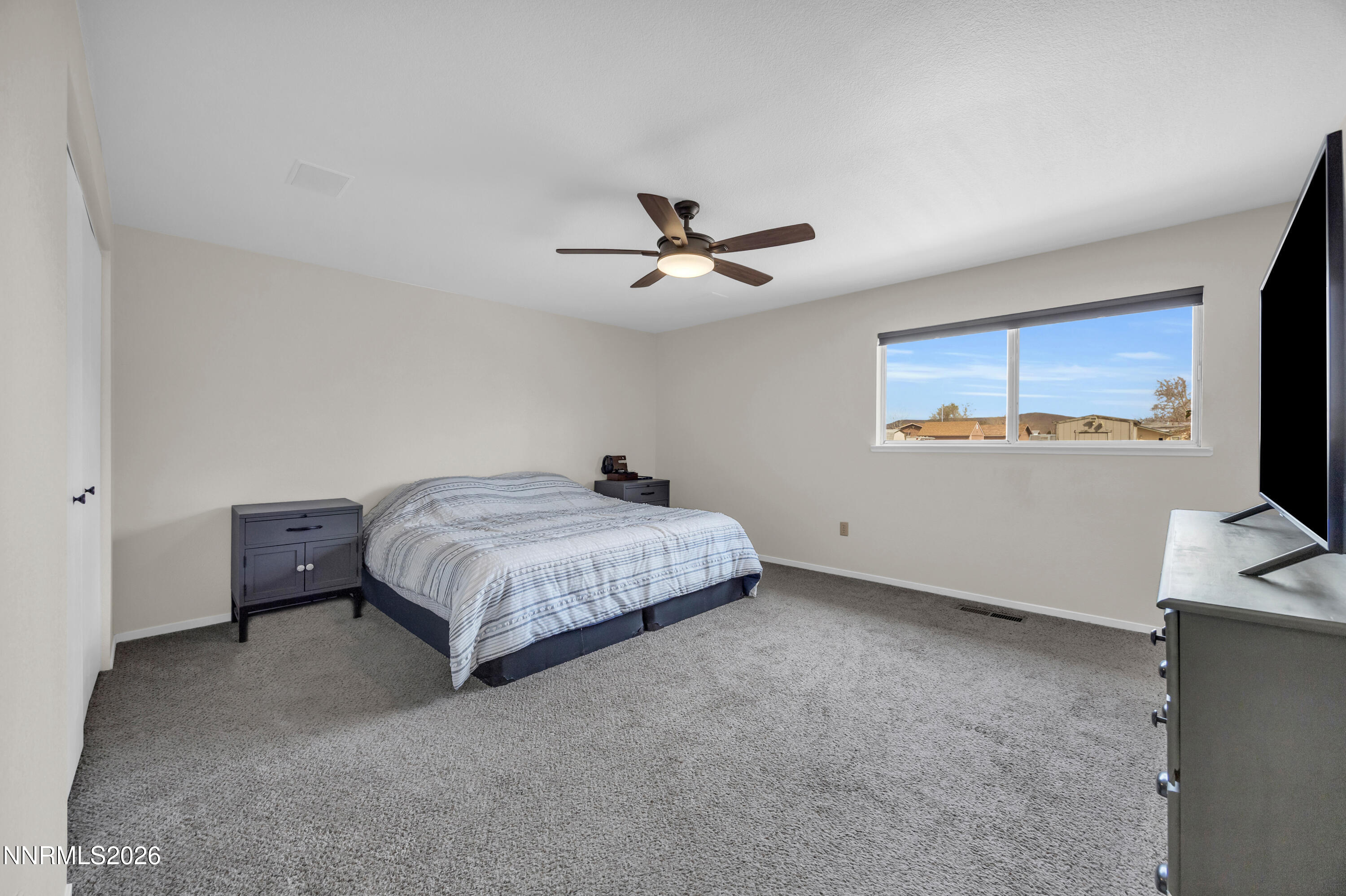 702 Ophir Court Dayton, NV 89403 - Photo 16 of 29 a bedroom with a bed and a flat screen tv