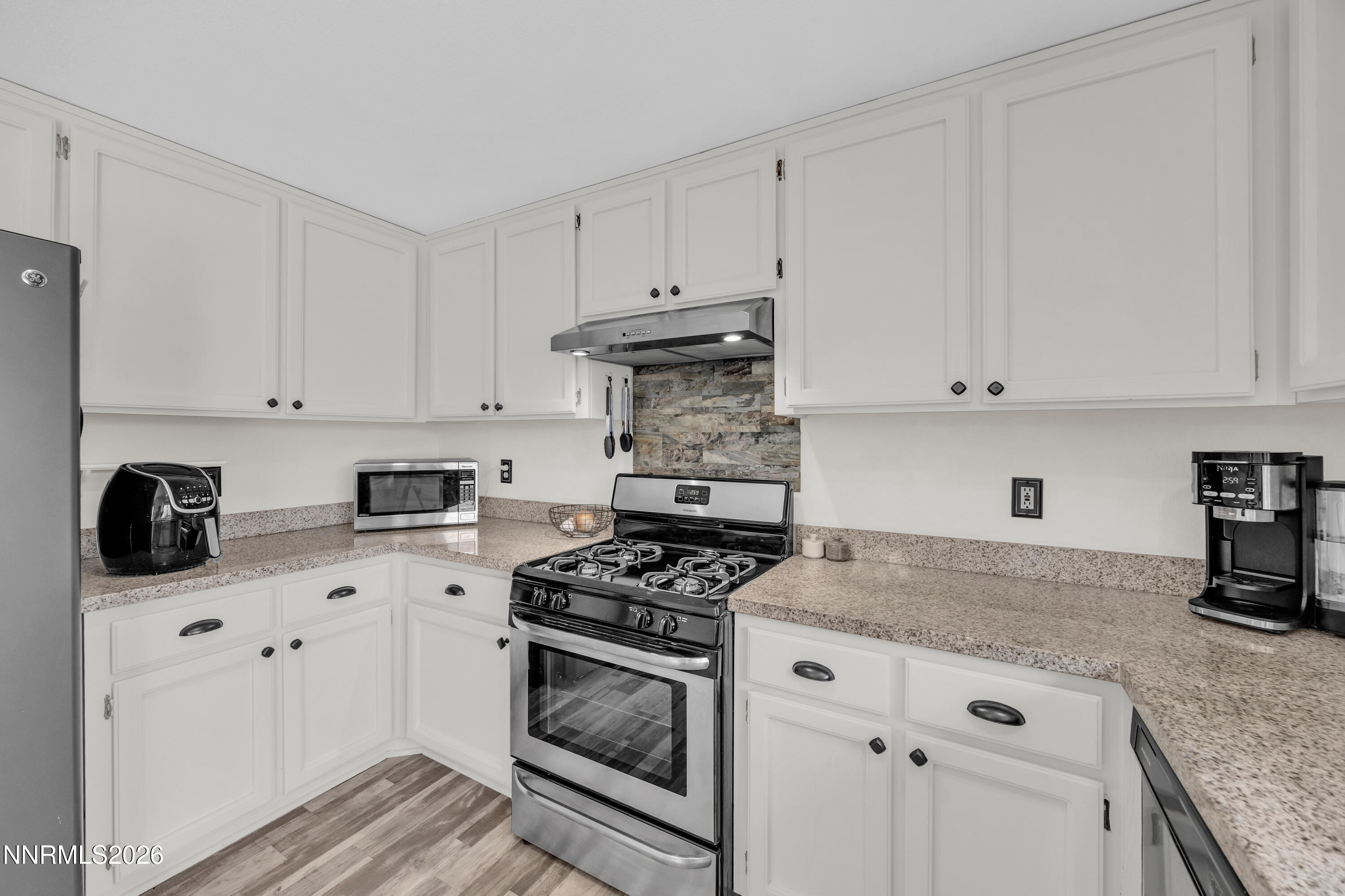 702 Ophir Court Dayton, NV 89403 - Photo 6 of 29 a kitchen with granite countertop white cabinets and white appliances