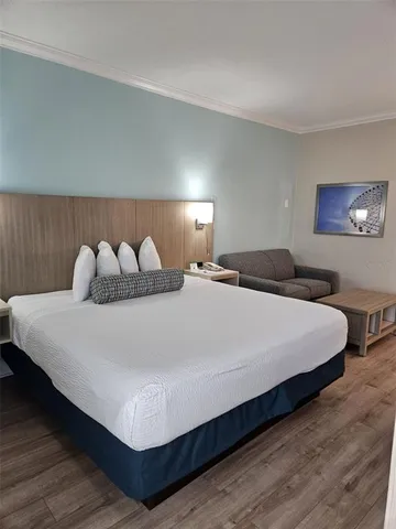 a large bed sitting in a bedroom and lamp