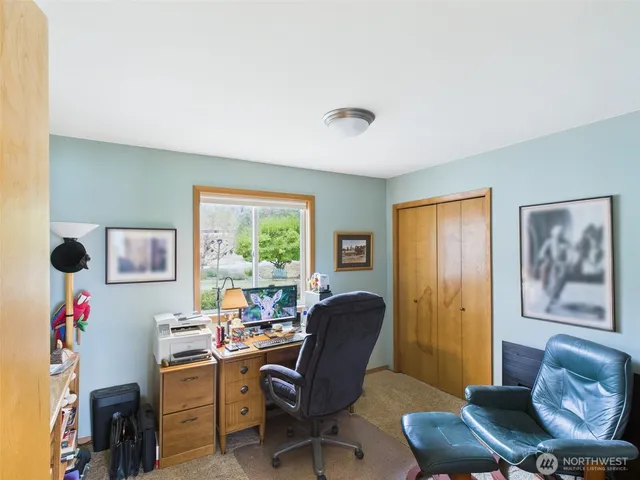 a view of a livingroom with workspace and a window