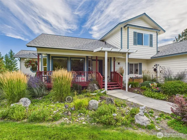 a view of house with a big yard and potted plants