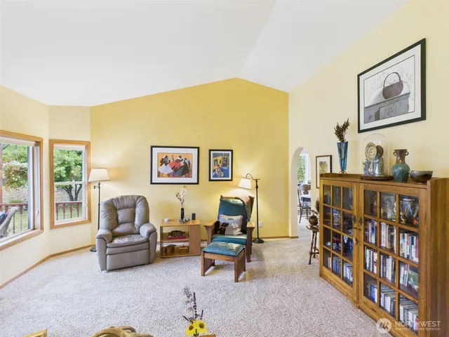 a living room with furniture and a book shelf