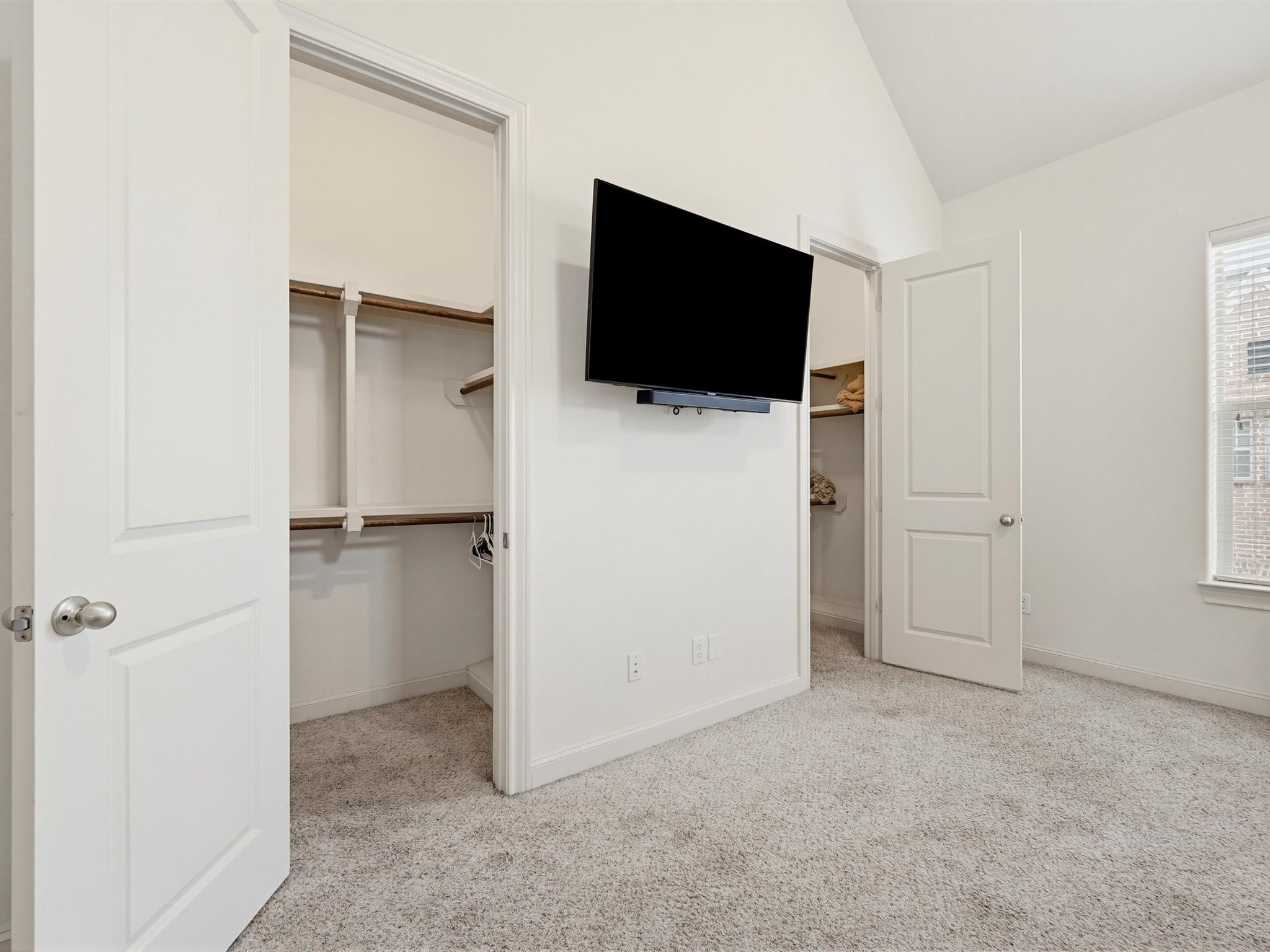9427 London Bridge Station Houston, TX 77045 - Photo 22 of 30 This room features soft carpet flooring, a mounted TV, and two open closets with ample storage space. The walls are painted in a neutral tone, and there's a window providing natural light.