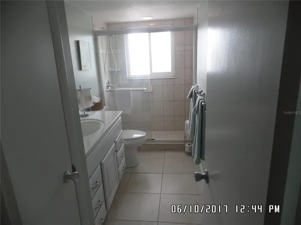 a bathroom with a granite countertop window a toilet and a shower