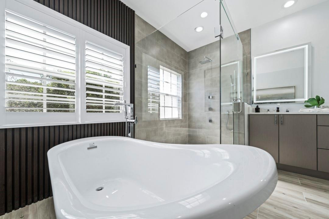 5520 Northeast Trieste Way Boca Raton, FL 33487 - Photo 3 of 57 a bathroom with a bathtub and a shower