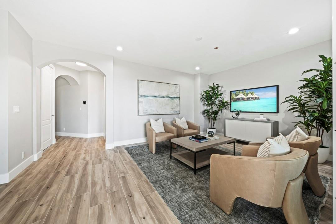 5520 Northeast Trieste Way Boca Raton, FL 33487 - Photo 9 of 57 a living room with couches a coffee table and a potted plant with wooden floor