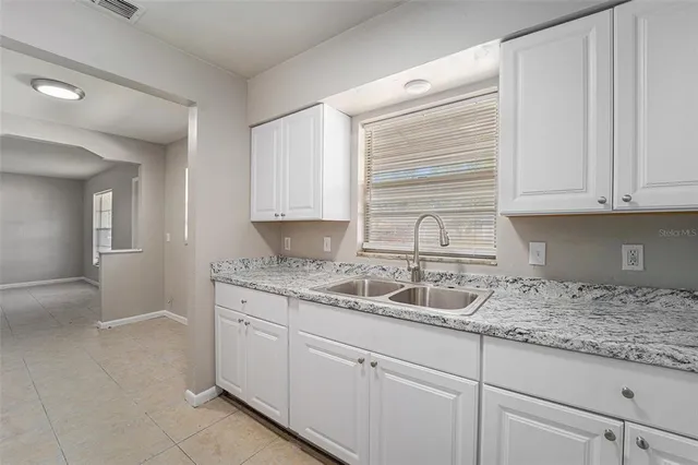 a kitchen with granite countertop a sink and cabinets