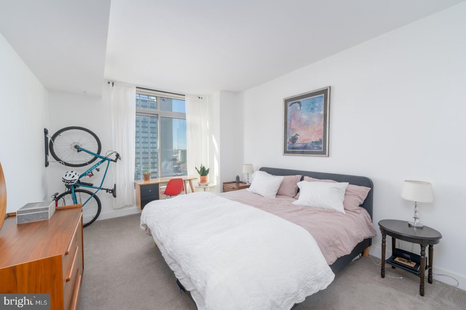 675 President Street, Unit 2402 Baltimore, MD 21202 - Photo 11 of 27 a bedroom with bed and a table with window