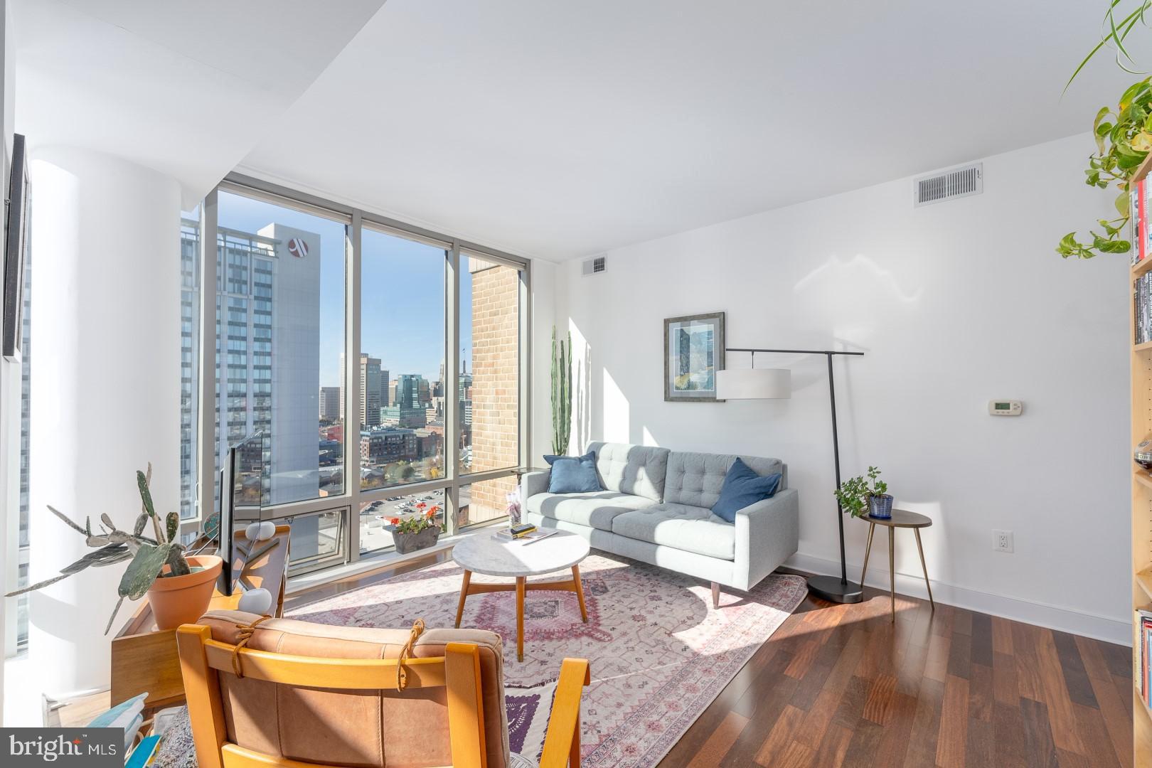 675 President Street, Unit 2402 Baltimore, MD 21202 - Photo 3 of 27 a living room with furniture and floor to ceiling windows