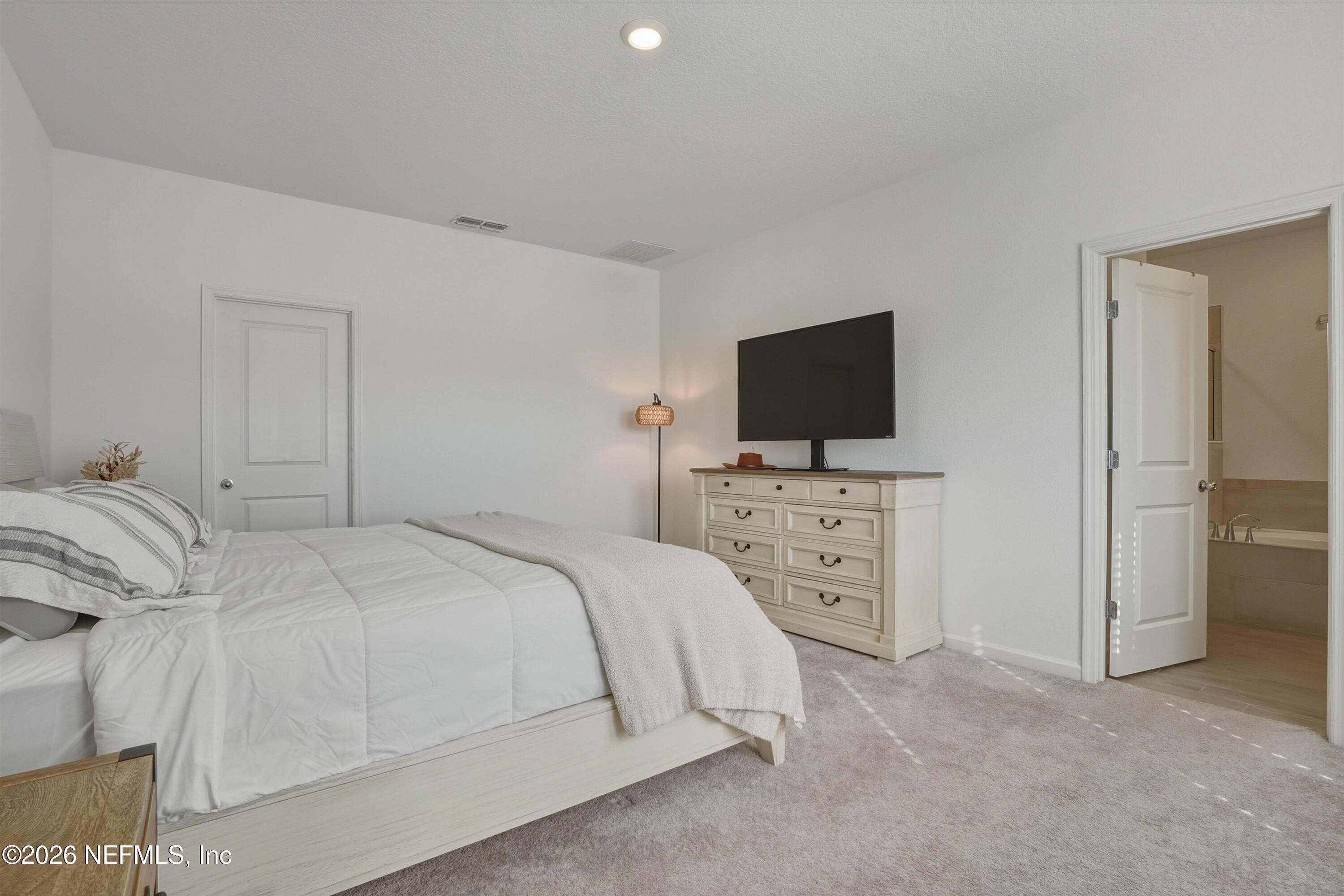 764 Lake Sinclair Street St. Augustine, FL 32084 - Photo 20 of 45 a bedroom with a bed and a flat tv screen on dresser