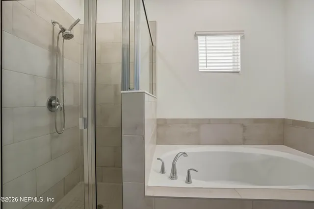 a bathroom with a tub sink and mirror