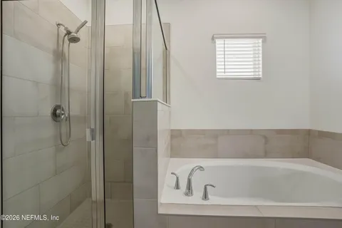 a bathroom with a tub sink and mirror