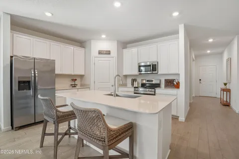 a kitchen with kitchen island a refrigerator stove microwave and cabinets