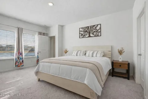 a spacious bedroom with a bed and a large window