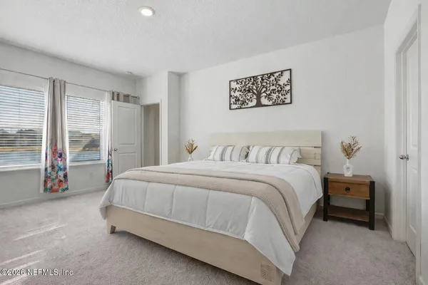 a spacious bedroom with a bed and a large window