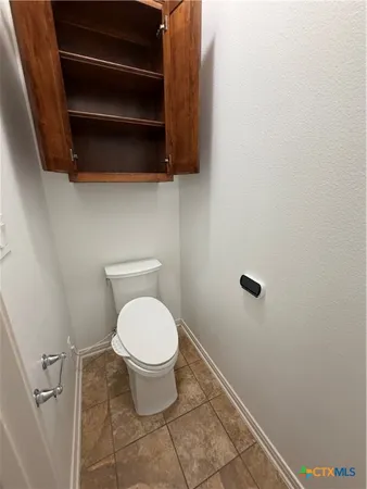 a bathroom with a toilet and a mirror