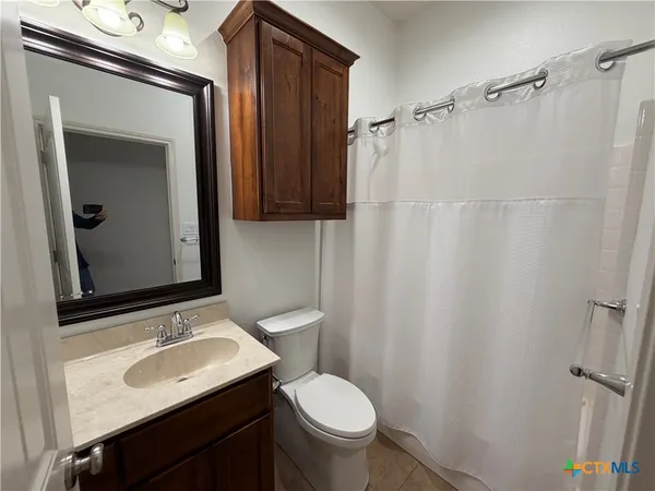 a bathroom with a sink toilet and mirror