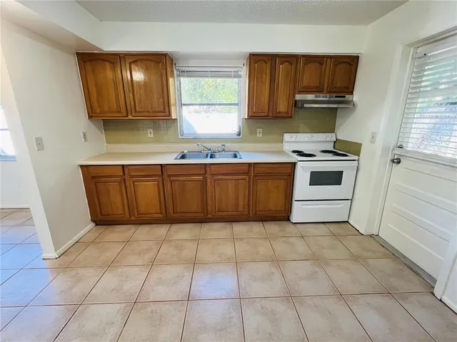 a kitchen with stainless steel appliances granite countertop a stove a sink and a microwave